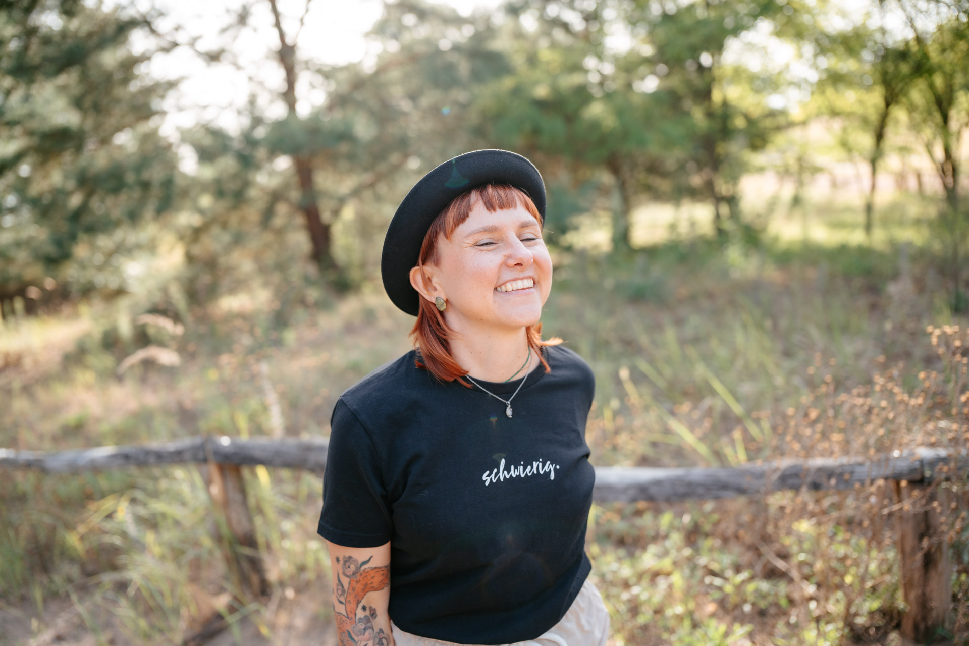 Hochzeitsfotografin Heidelberg Frau Eska in der Natur: Lächelnd in der Sonne mit Hut auf dem Kopf