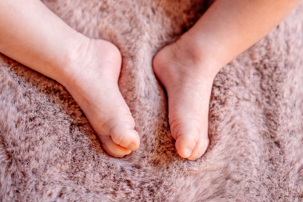 Babyfotos Frankfurt: Neugeborene Babyfüße auf weichem rosa Fell – liebevolles Detailbild