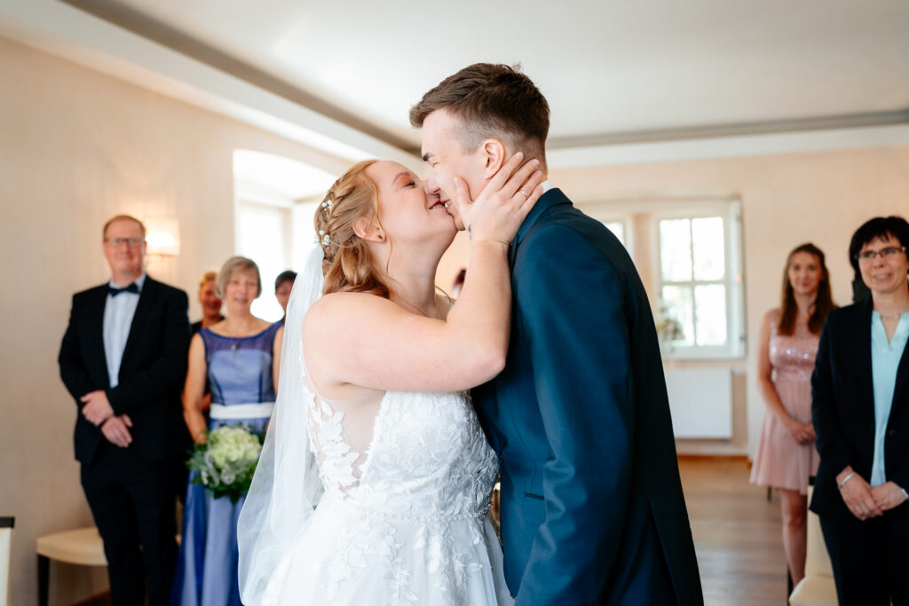 Hochzeitsfotos: Hochzeitspaar küsst sich im Standesamt nach der Trauung