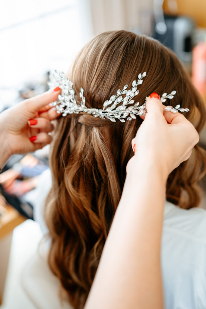 Hochzeitsbilder: Braut bekommt beim Getting Ready den Haarschmuck kunstvoll ins Haar gesteckt