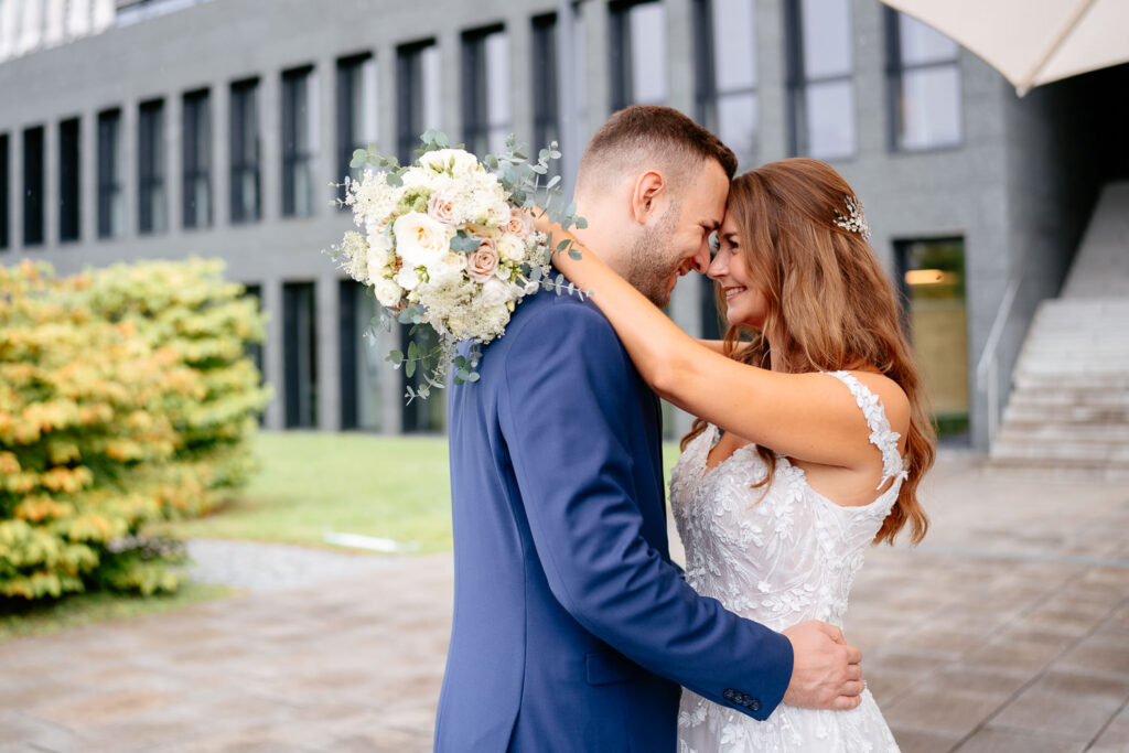 Hochzeitsbilder: Emotionaler First Look – Brautpaar umarmt sich liebevoll im Freien