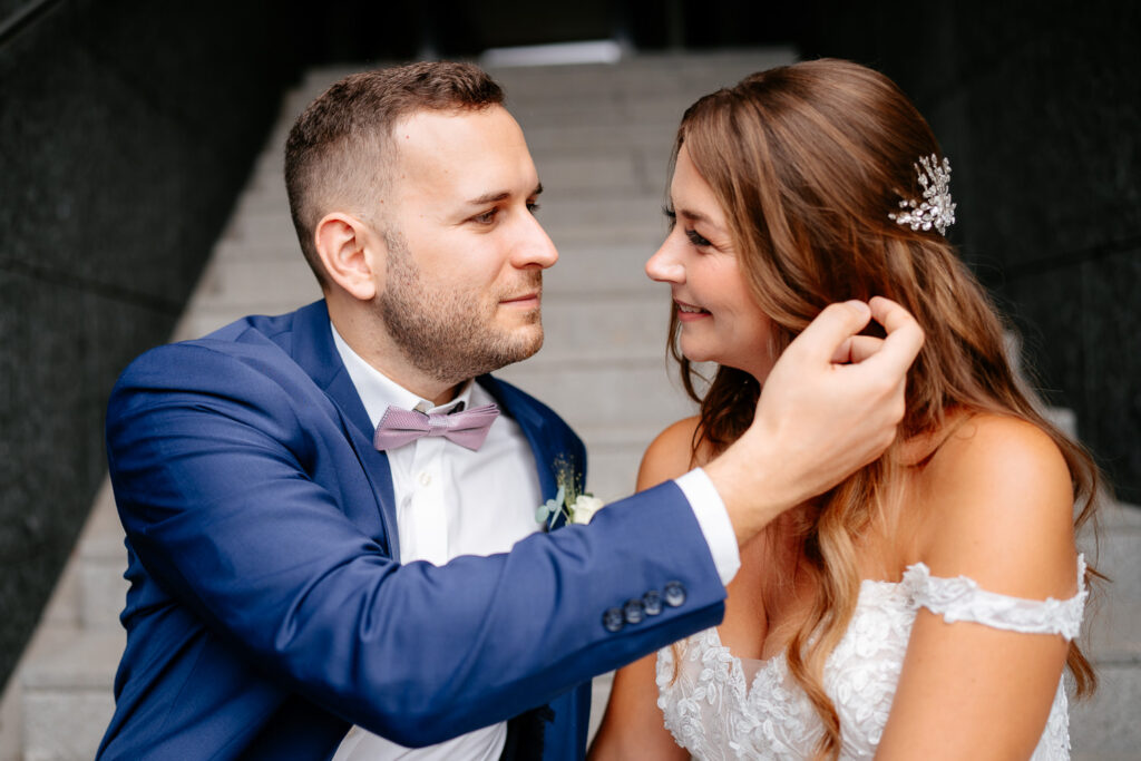 Verliebte Hochzeitsfotos: Bräutigam streicht Braut eine Haarsträhne hinter das Ohr