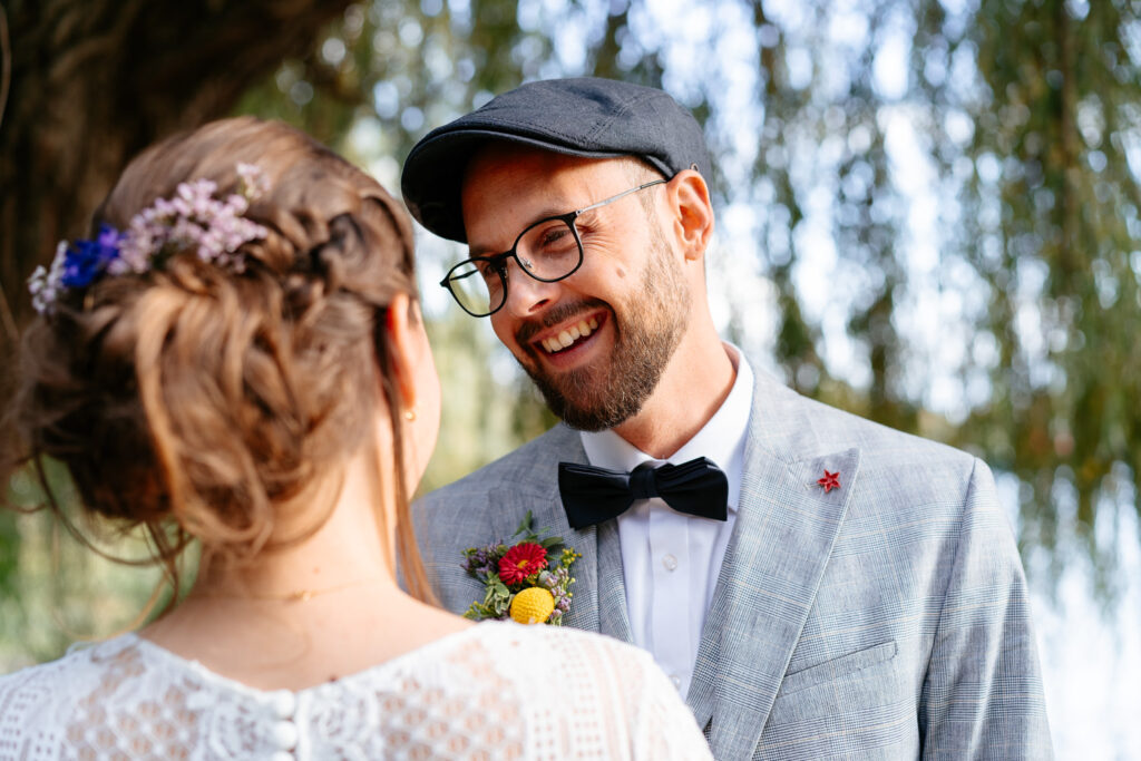 Hochzeitsfotos: Bräutigam und Braut stehen sich gegenüber – er lächelt sie verliebt an