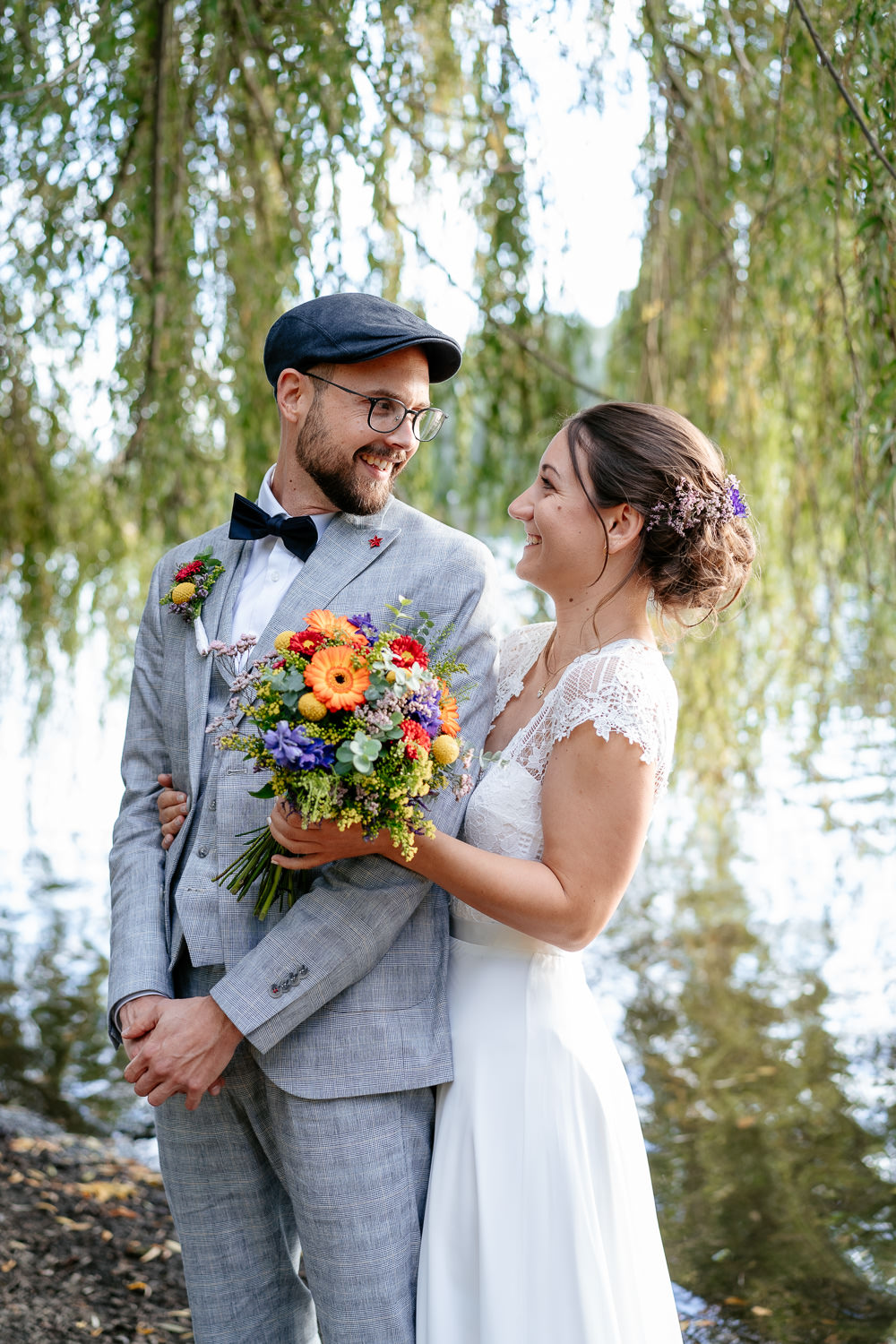 Hochzeitsfotografin Karlsruhe fängt emotionale Hochzeitsfotos ein: Die Braut hält den Bräutigam liebevoll im Arm, beide schauen sich an
