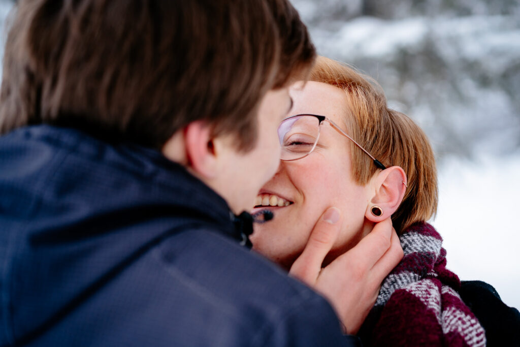 Pärchen Fotoshooting: Winterliches Portrait – er küsst sie sanft und liebevoll